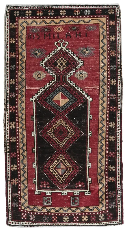 Full overhead view of a vintage red tribal geometric rug on a white background