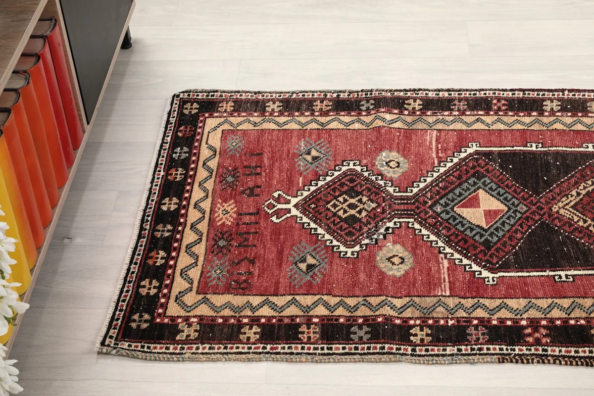 Overhead angle of the red tribal rug on a light floor, next to a modern cabinet