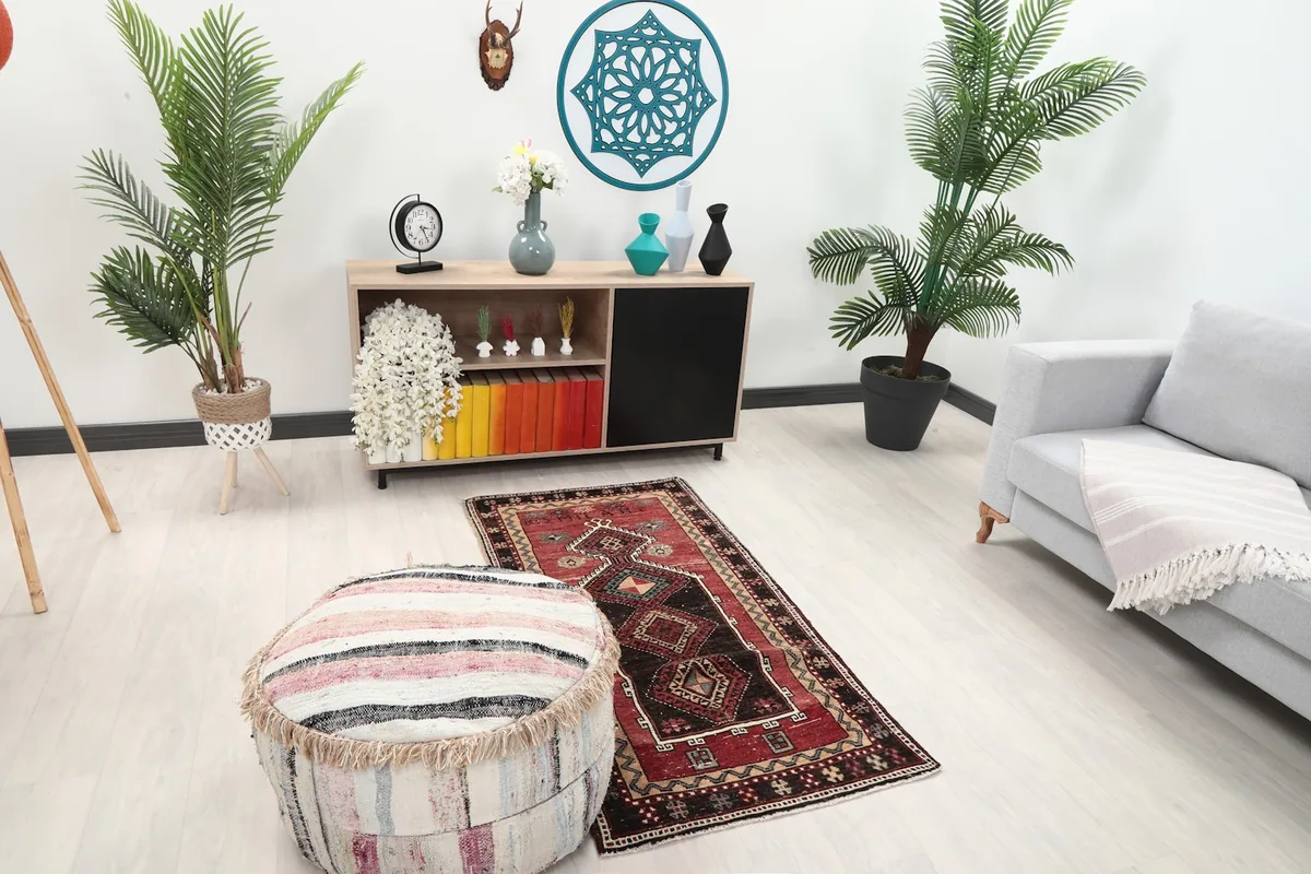 Angle view of the red tribal geometric rug in a living room with a sofa and pouf