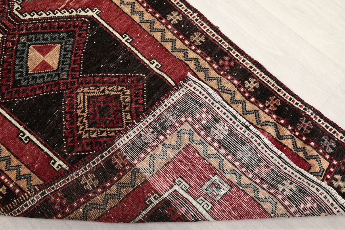 Folded corner showing the back of the hand-knotted wool pile on cotton foundation