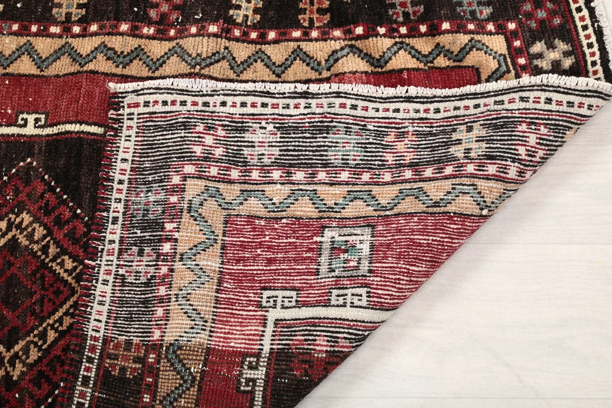 View of the rug's reverse side, revealing the knotting and fringe structure