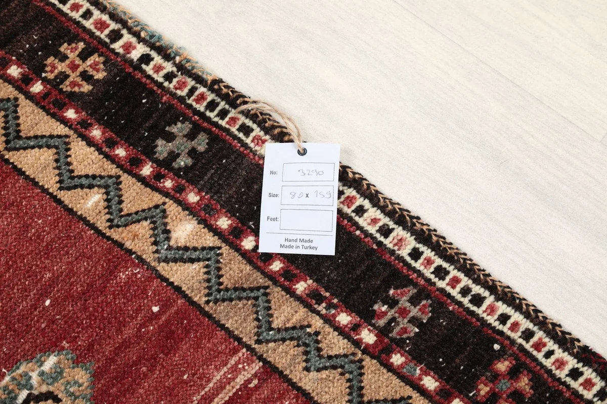 Close-up of the rug's corner with a product tag showing origin and material details