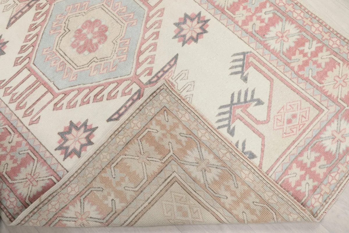 Corner of the rug folded back to show the reverse side of the hand-knotted construction