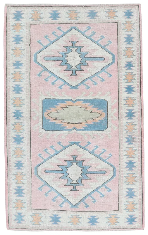 Full top view of the rose and blue geometric Anatolian vintage rug on a white background.