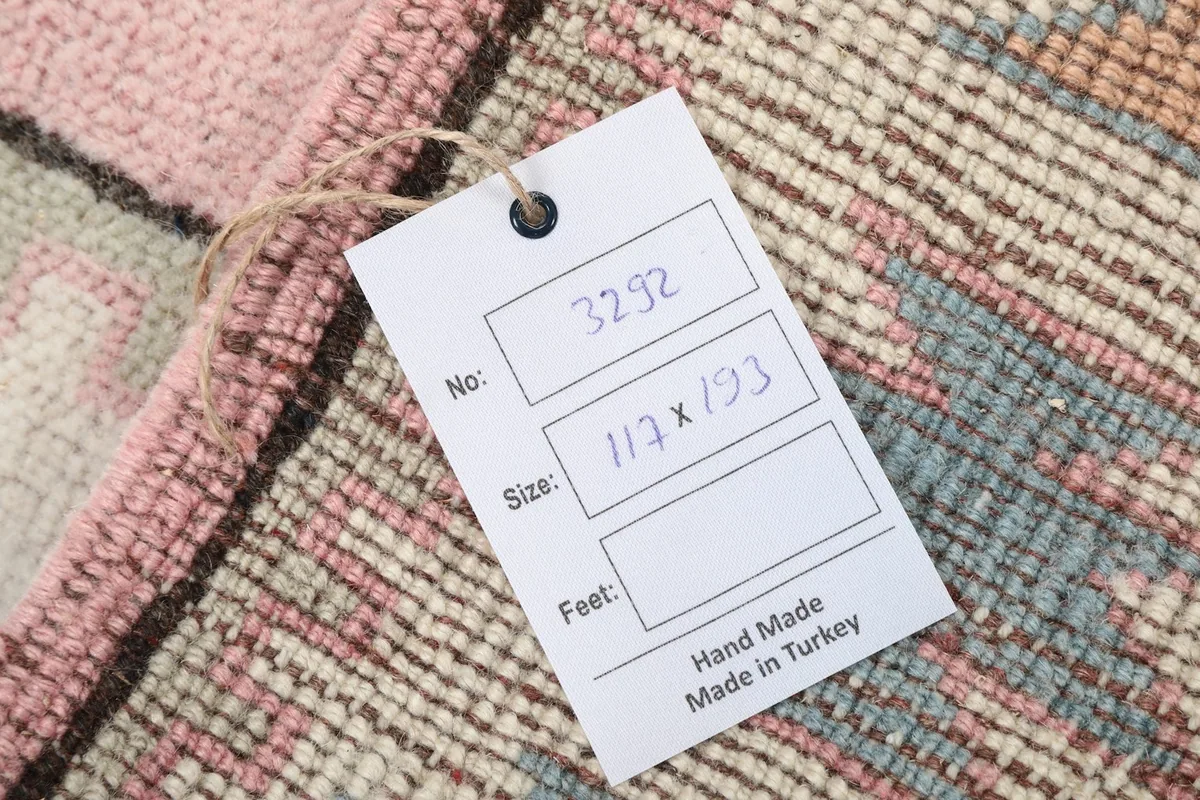 Close-up of the rug's tag displaying its unique number and dimensions in centimeters.