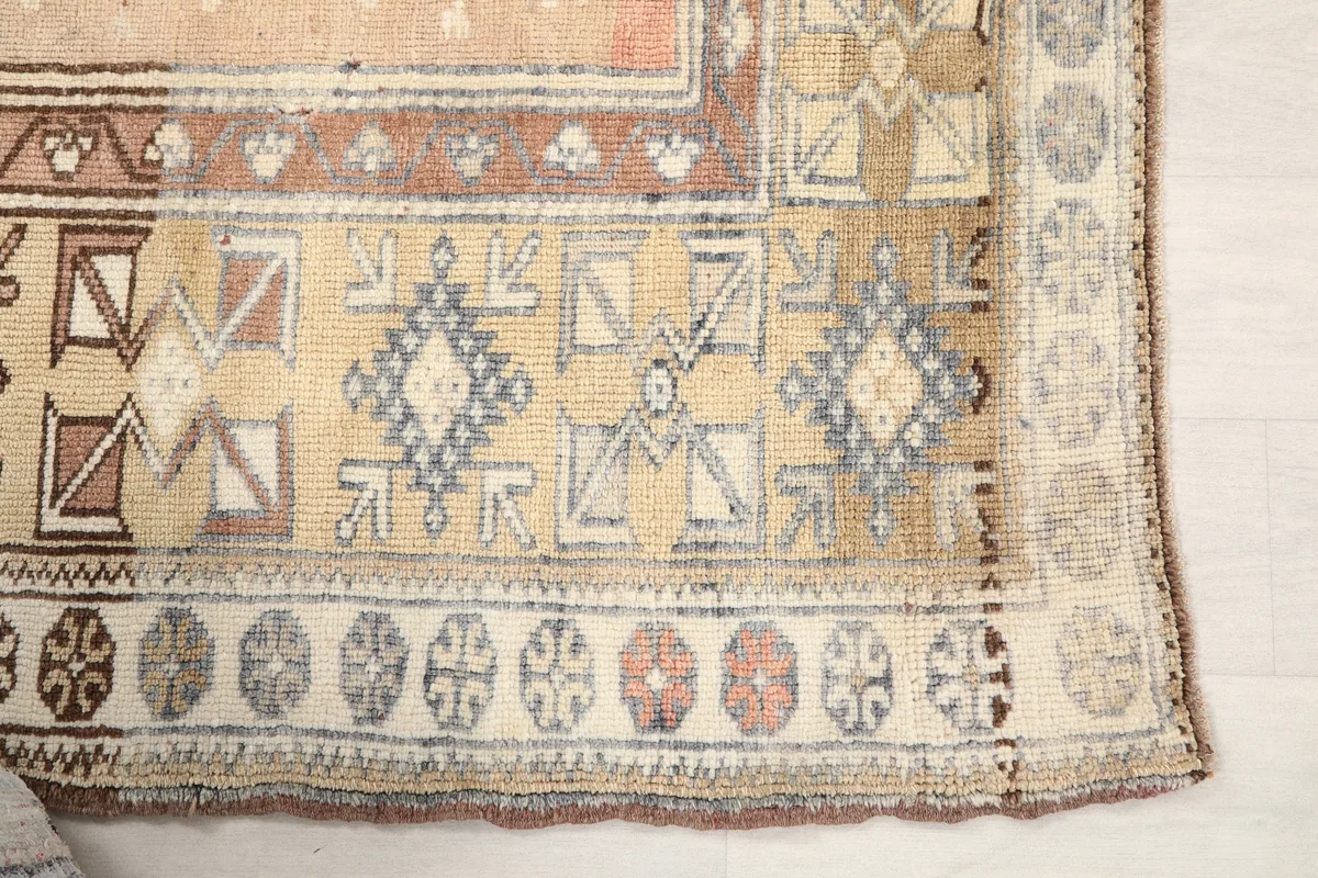 Detail of the Faded Rose Tribal Anatolian Rug showing geometric motifs in brown, gray, and beige.