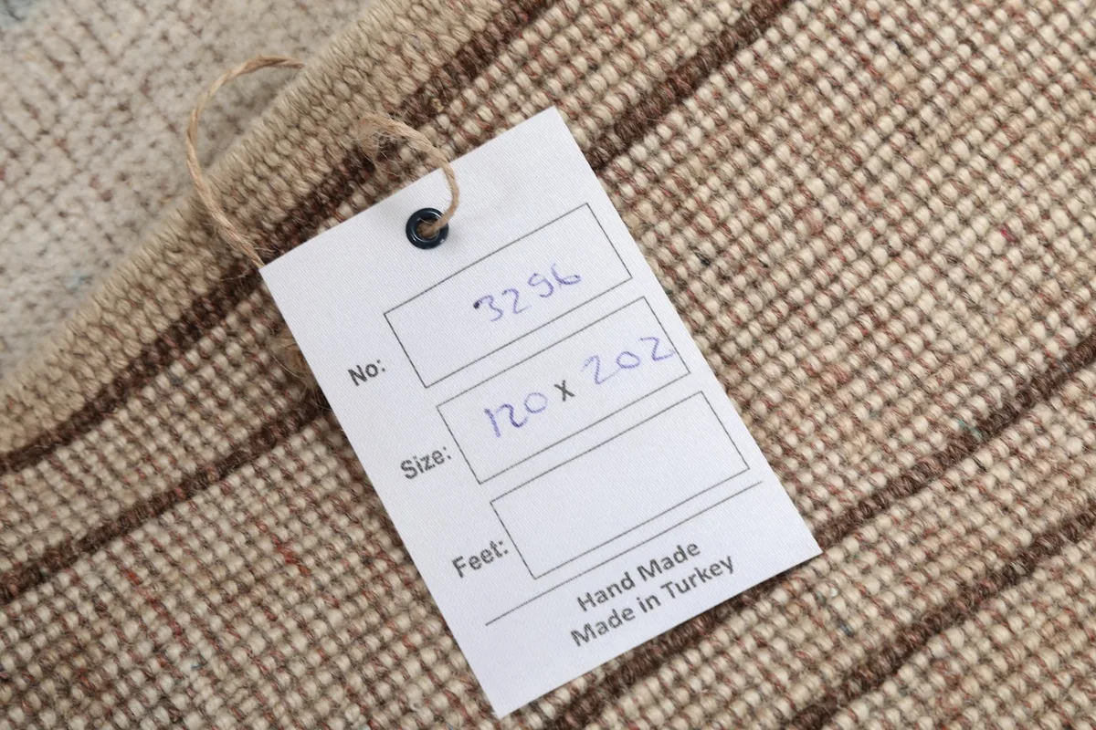 Close-up of the rug's back, revealing the hand-knotted wool pile on cotton foundation and size tag.