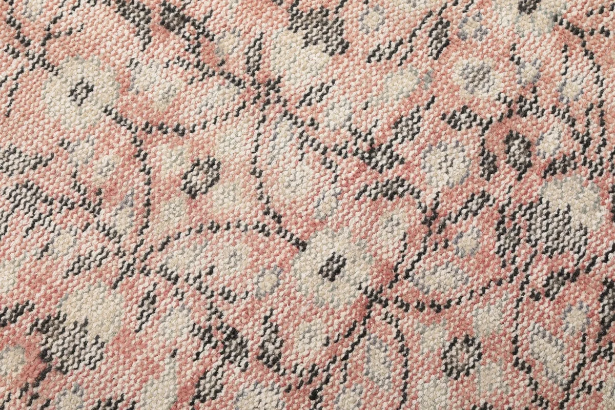 Macro shot of the hand-knotted wool pile, revealing the texture and individual knots of the rug.