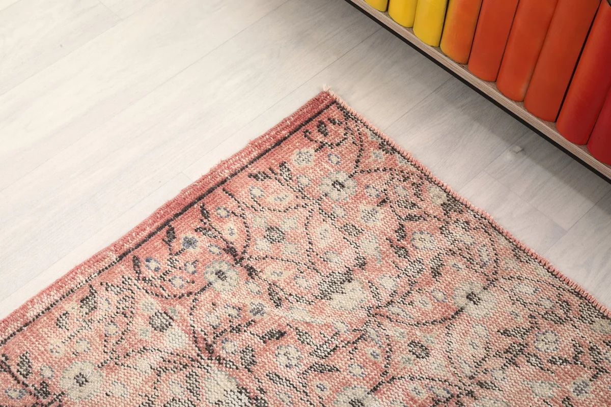 Close-up of a corner of the rug, showing the distinct border design and the overall pattern.