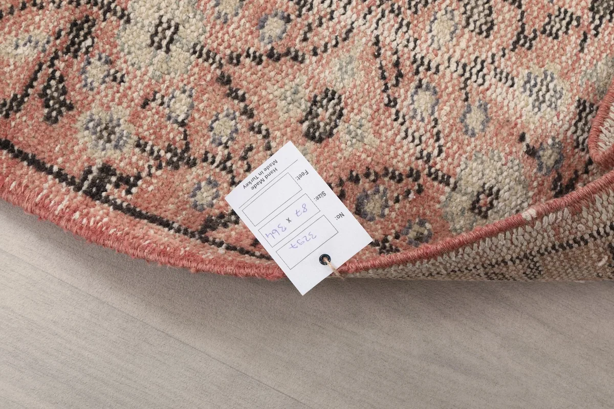 Close-up of the rug's corner with a product tag, showing the texture and the label.