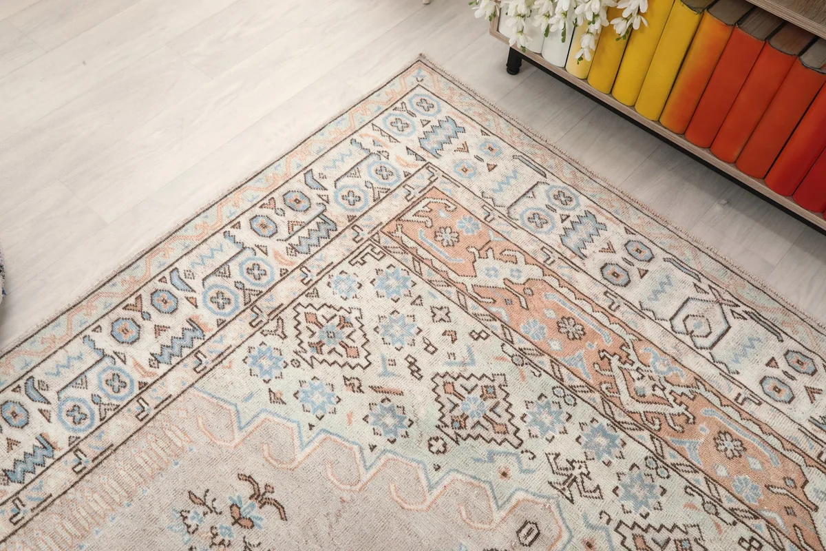 Corner view of the rug, showing the intricate border patterns and the transition to the main field
