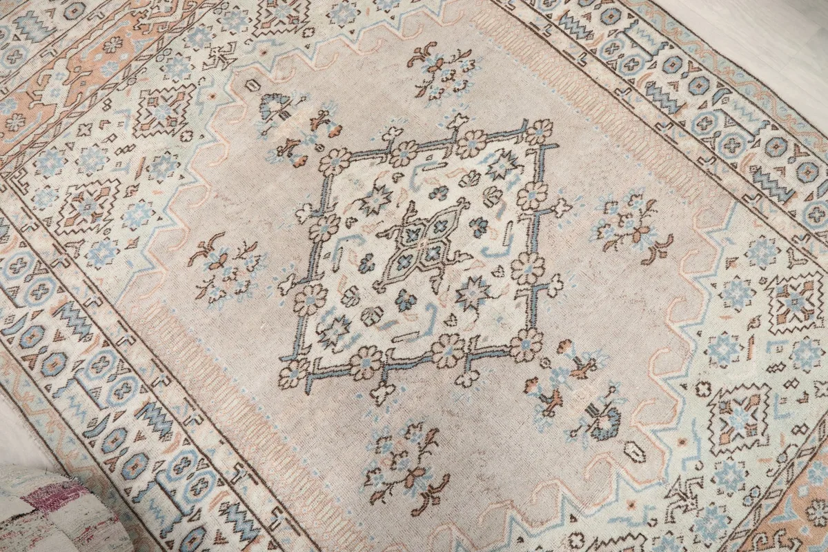 Angled overhead view highlighting the rug's central medallion and various tribal elements