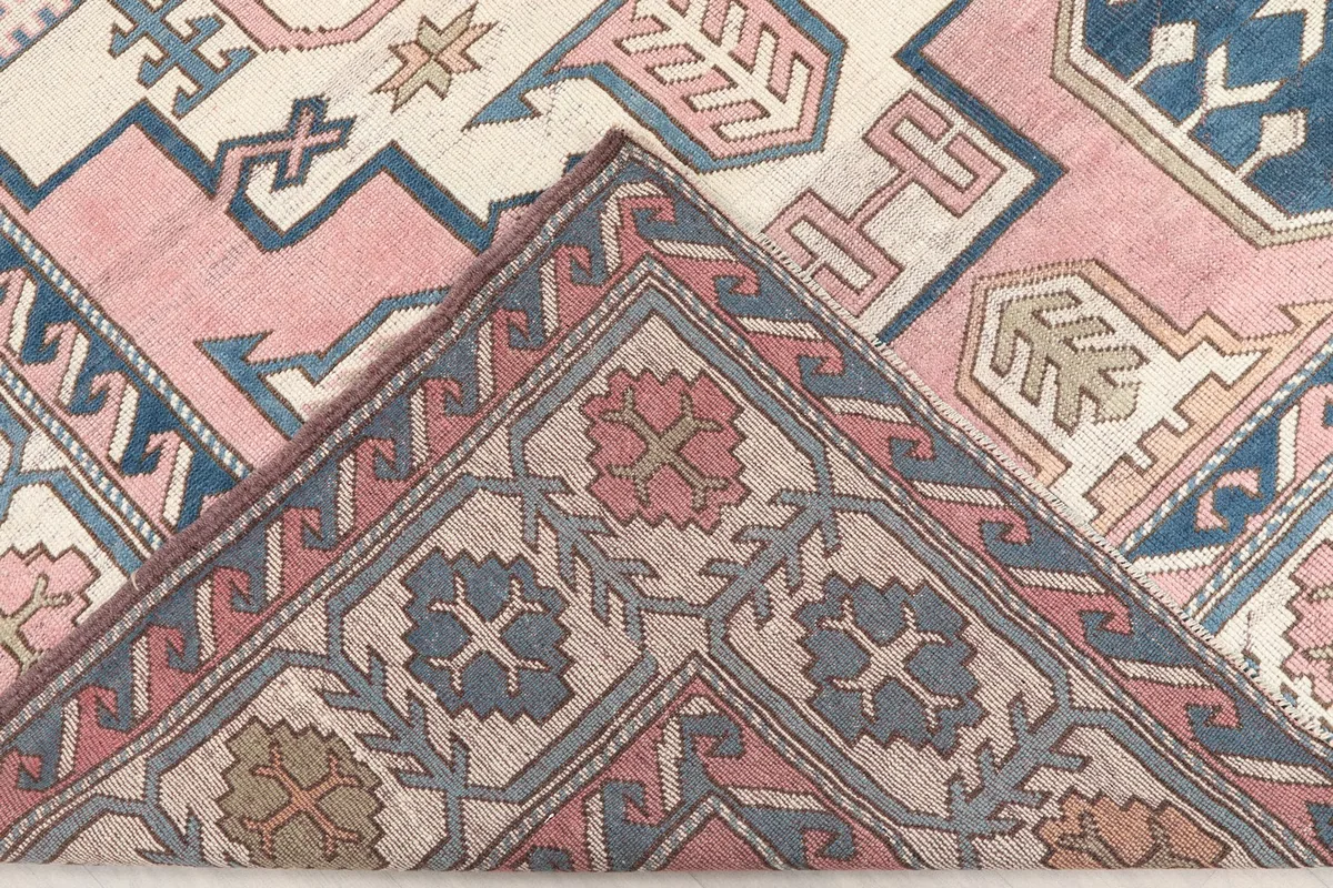 Folded corner of the rug revealing the back of the hand-knotted wool and cotton foundation