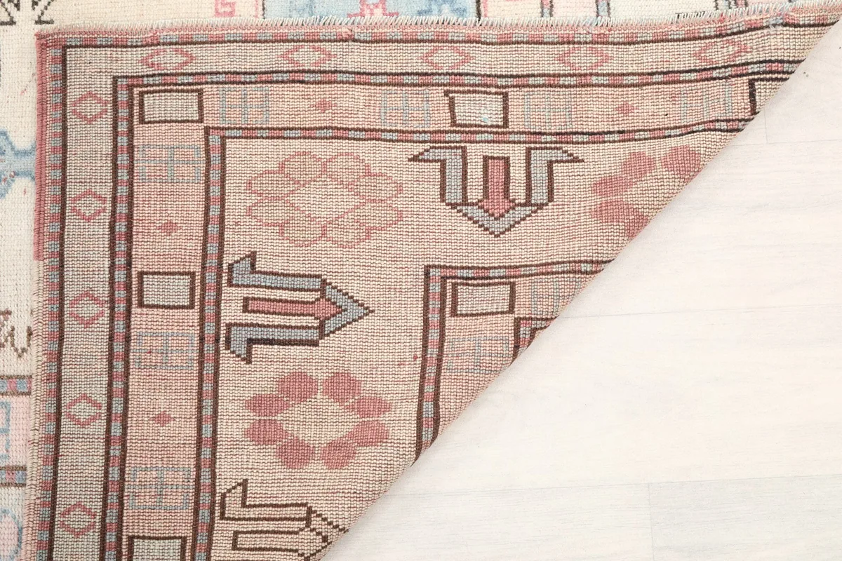 Close-up of the rug's fold, revealing the wool pile and cotton foundation texture