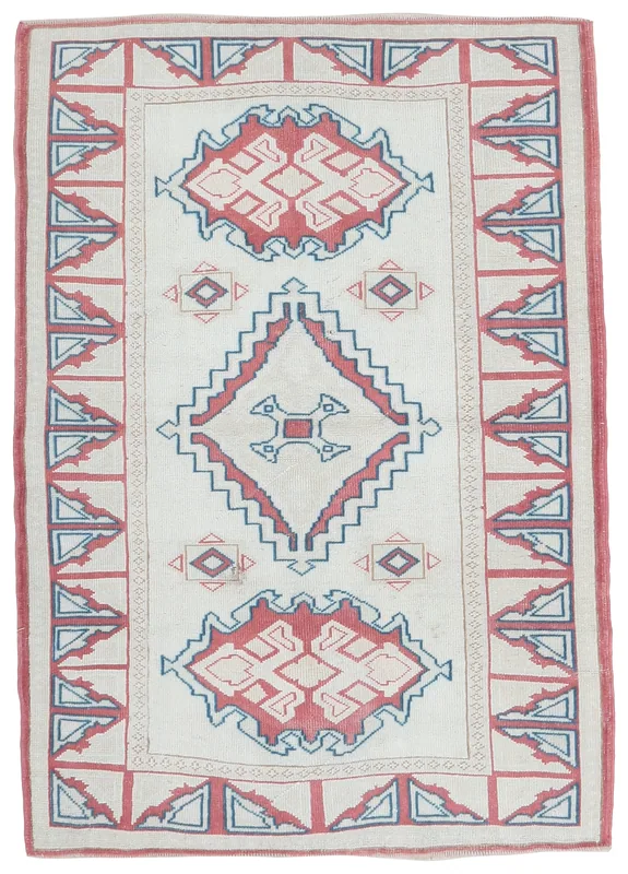 Full overhead view of the ivory, red, and blue geometric vintage Anatolian rug.