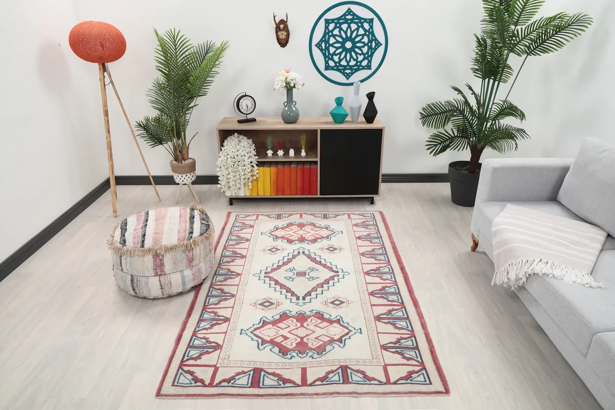 Vintage Anatolian rug displayed in a living room setting with a light gray sofa and wooden console.