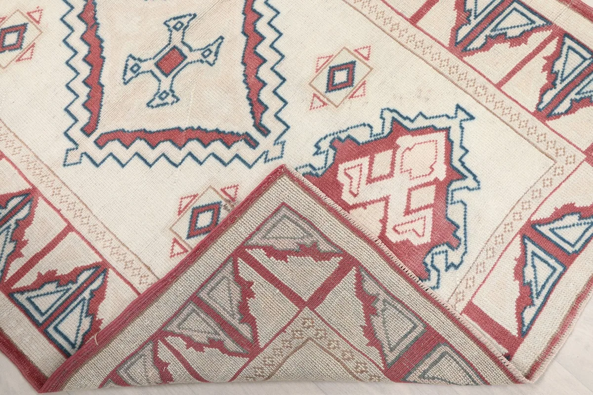 A corner of the rug folded back to show the reverse side and knotting detail.