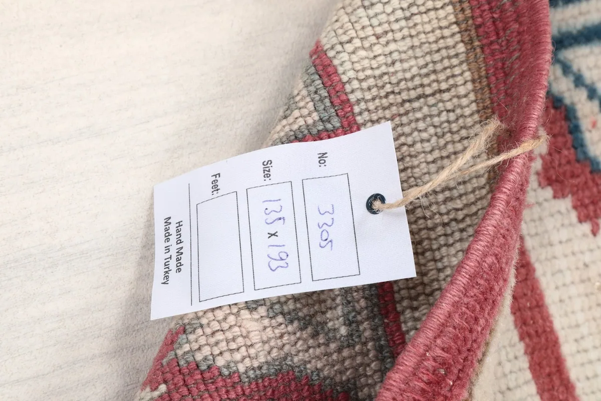 Product tag showing the rug's dimensions (135x193 cm) and origin.