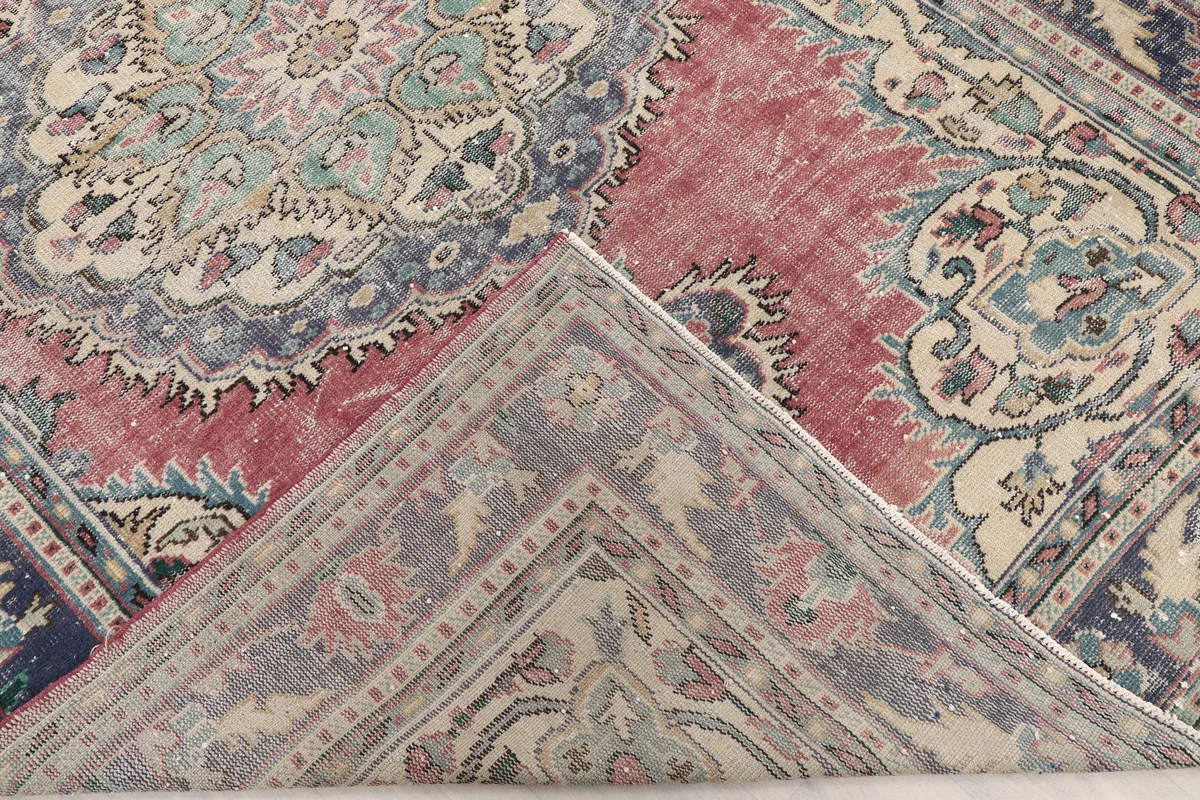 Corner of the Faded Rose Medallion Anatolian Rug folded to show the hand-knotted cotton foundation