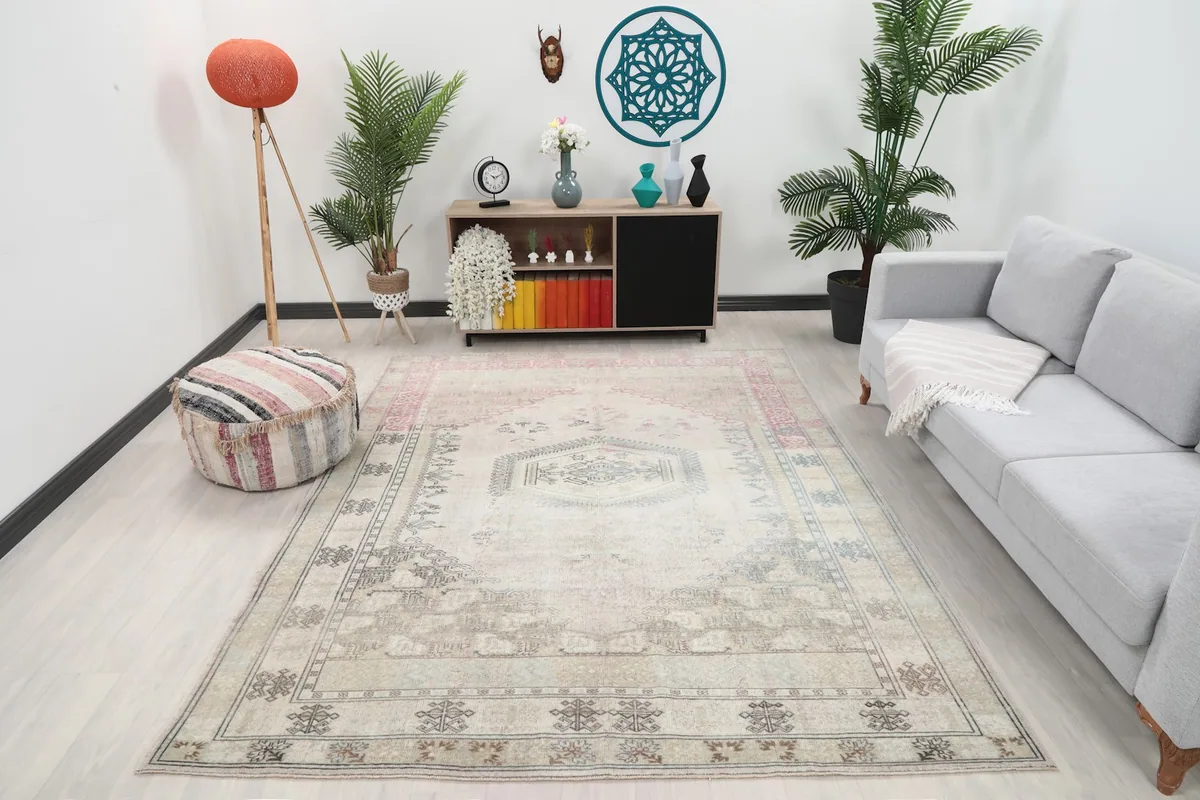 Vintage beige and rose rug in a living room setting with a light gray sofa