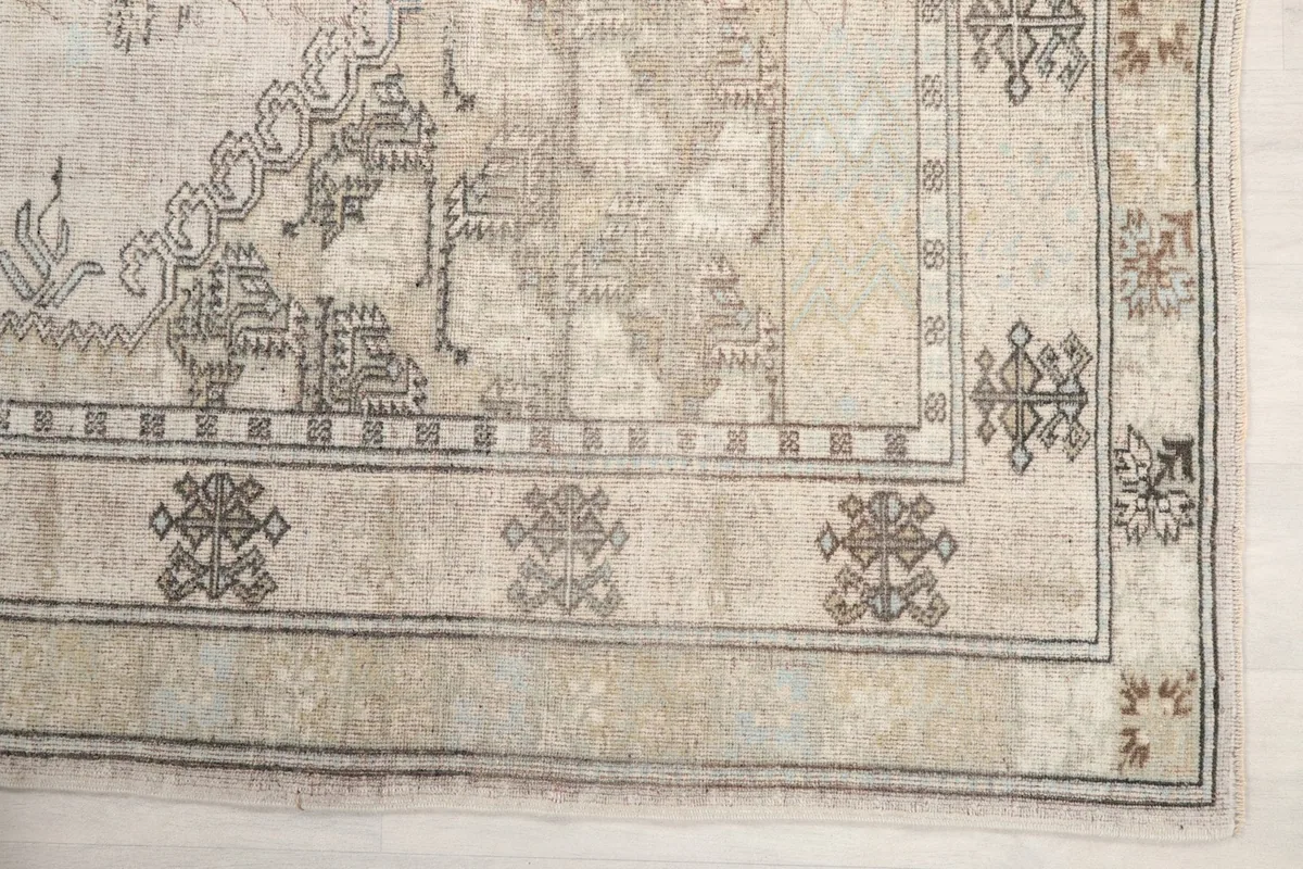 Detailed view of the corner border showing tribal geometric patterns in gray and beige