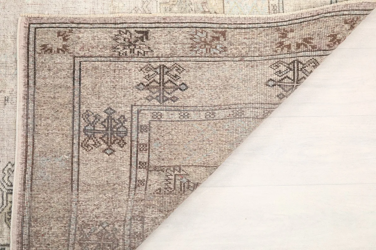 Underside view of the rug, showing the knotting and foundation from the back