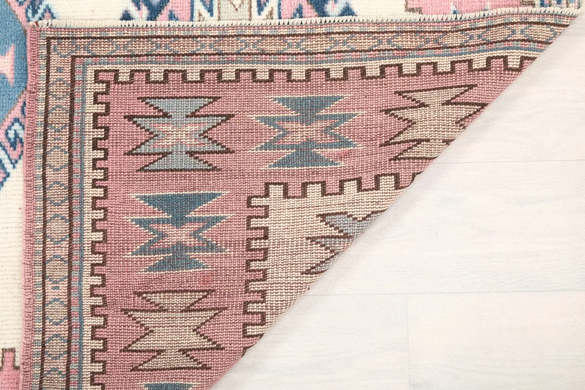 Another view of the back of the vintage rug, showing the knotting structure and foundation