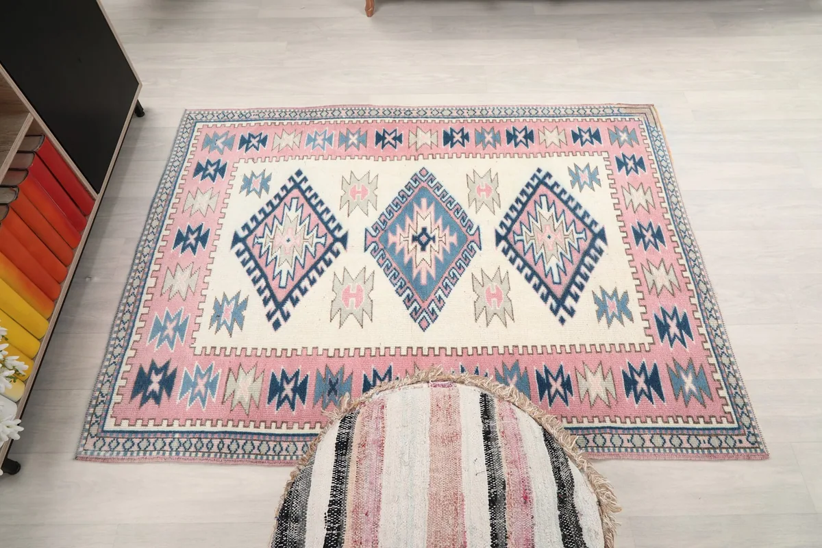 Overhead shot of the ivory, pink, and blue rug, emphasizing its overall design and proportions