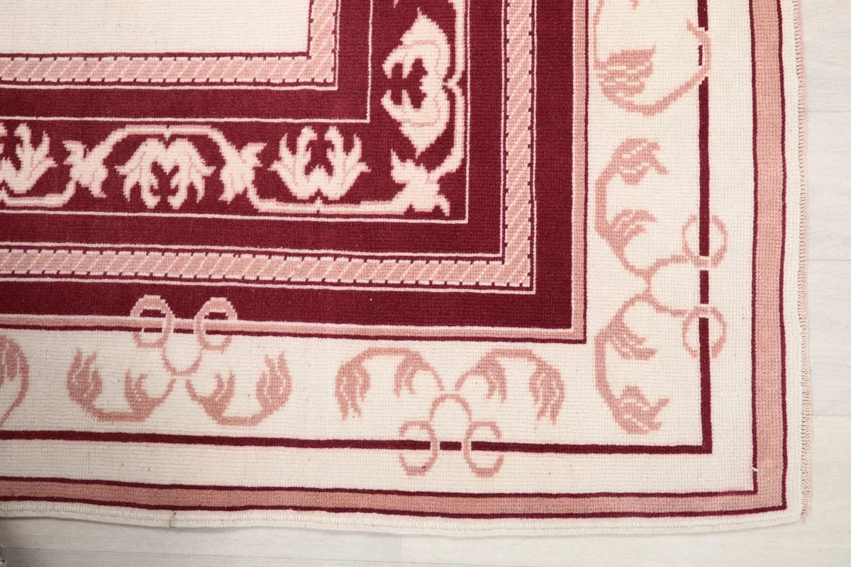 Detailed view of the corner border with rose floral motifs on an ivory background
