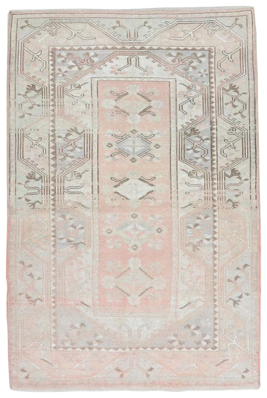 Full overhead view of the rose and beige geometric vintage Anatolian rug on a white background