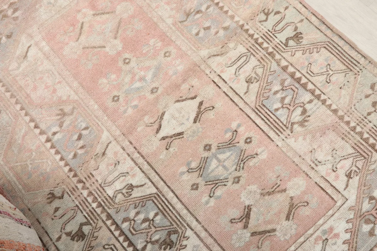 Angled view highlighting the central geometric patterns and color variations in the rug's pile