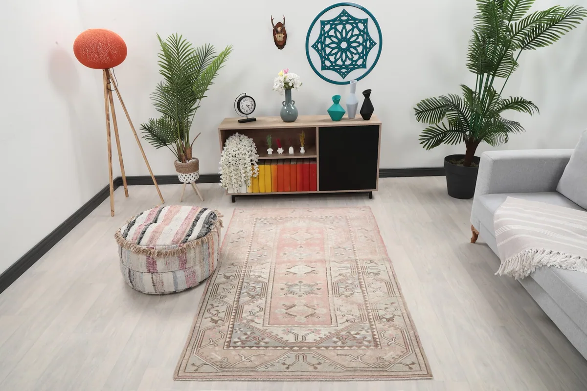 Vintage Anatolian rug with rose and beige colors placed in a modern living room setting