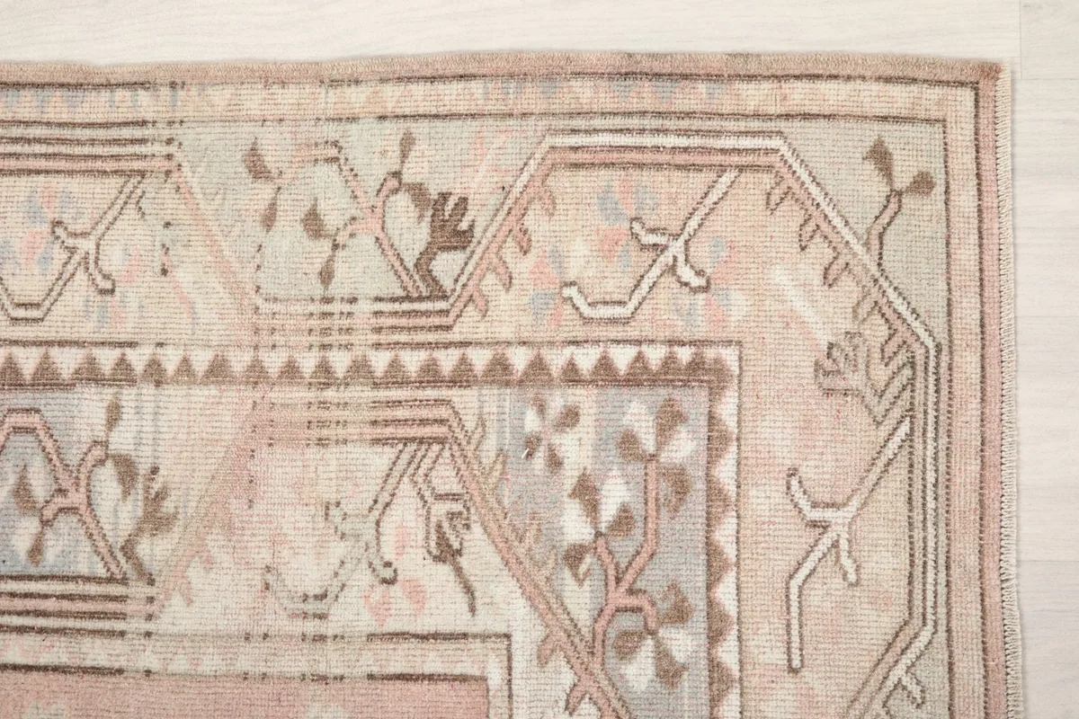 Detail of the top right corner, showing the geometric border design in beige and brown tones