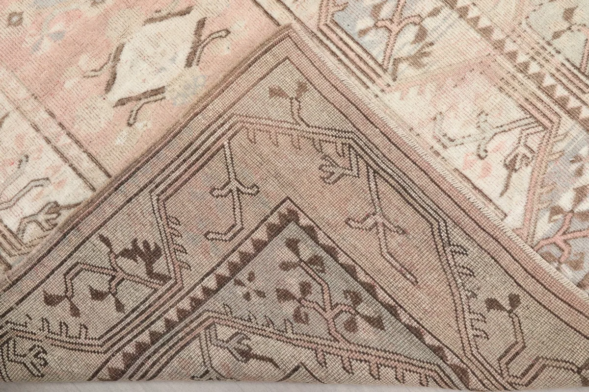 View of the back of the rug, folded to show the hand-knotted construction and cotton foundation