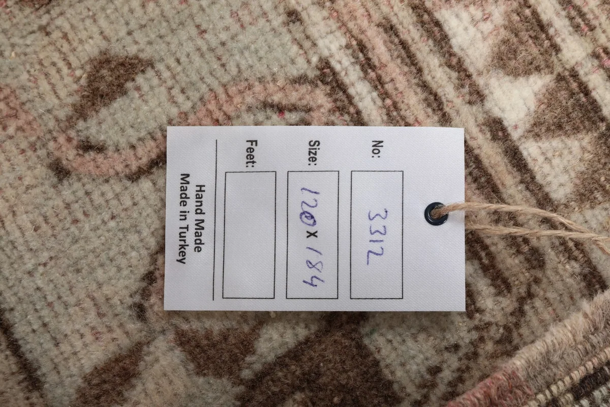Close-up of the product tag, indicating the size 120x184 cm and handmade origin
