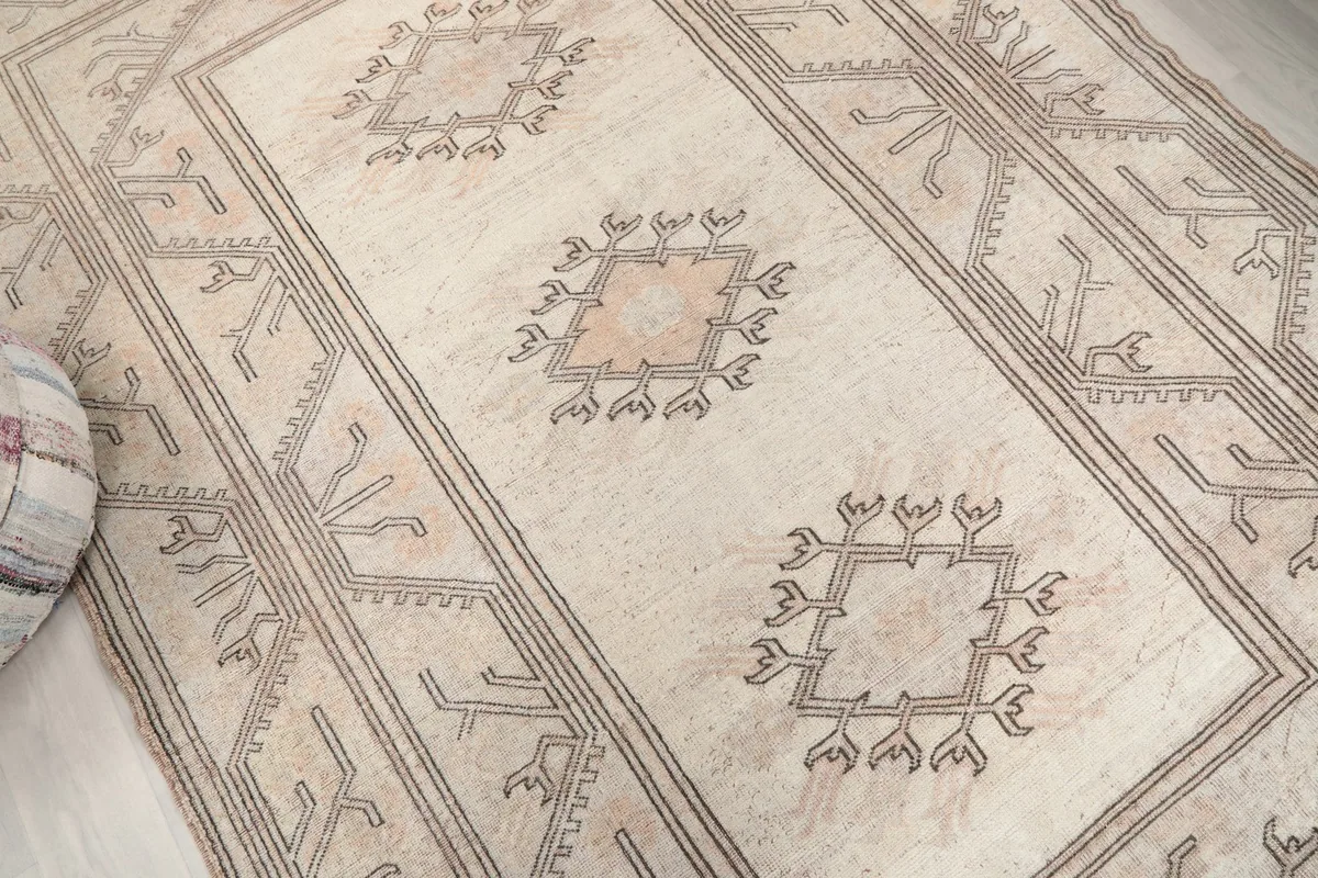 Close-up of the central motifs and field color, showing wool texture and subtle wear