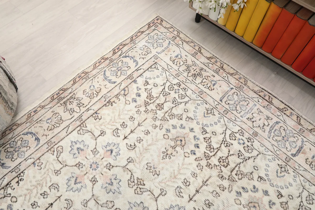 Corner view of the rug, showing the border design and the soft color palette