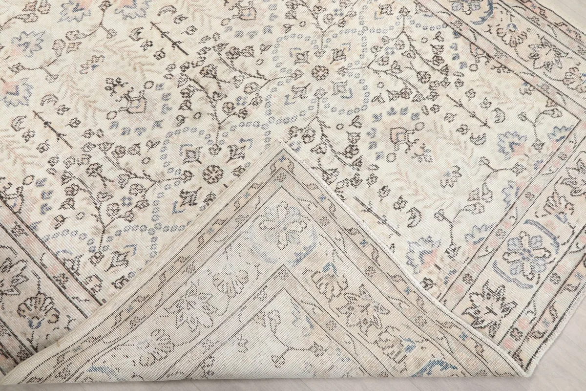 Corner of the rug folded back to reveal the cotton foundation and reverse side of the knots