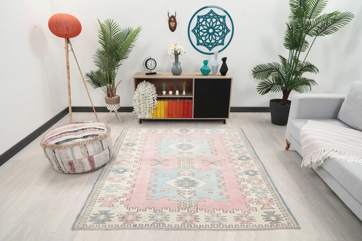 Vintage pink and blue rug displayed in a living room setting with modern furniture