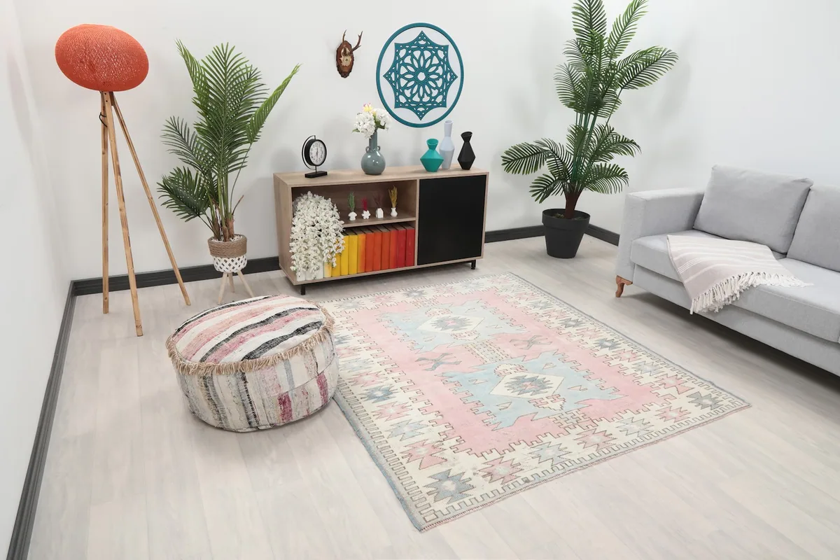 Angle view of the Anatolian rug in a room, showing its placement relative to a sofa and ottoman