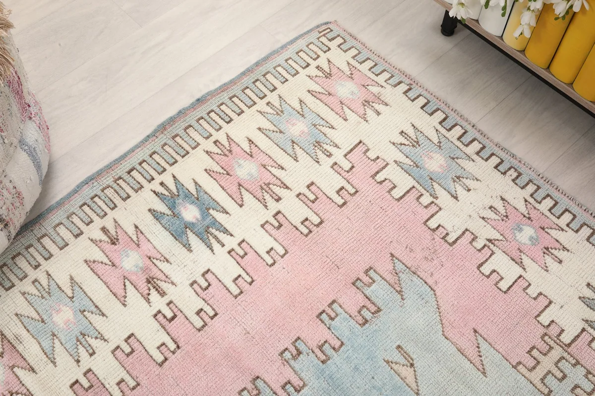 Close-up of the rug's border design, revealing the subtle gray and ivory tones