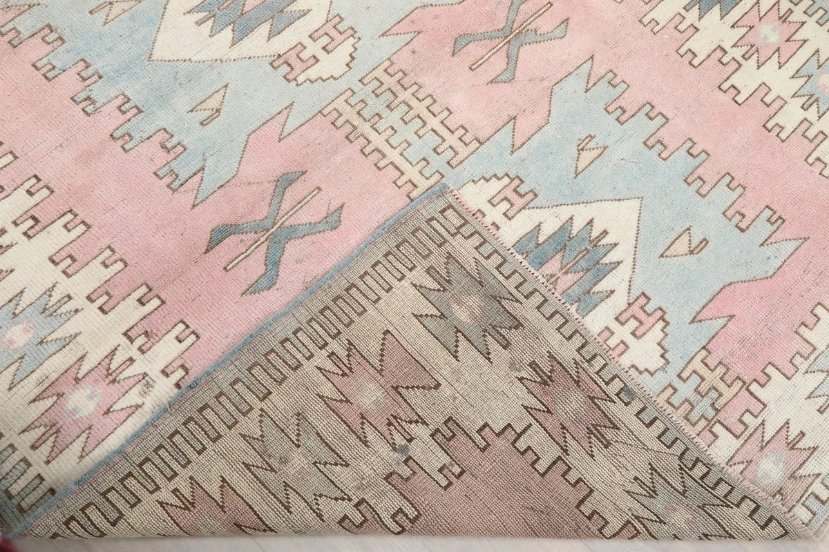 Corner of the rug folded back to show the reverse side and hand-knotted construction