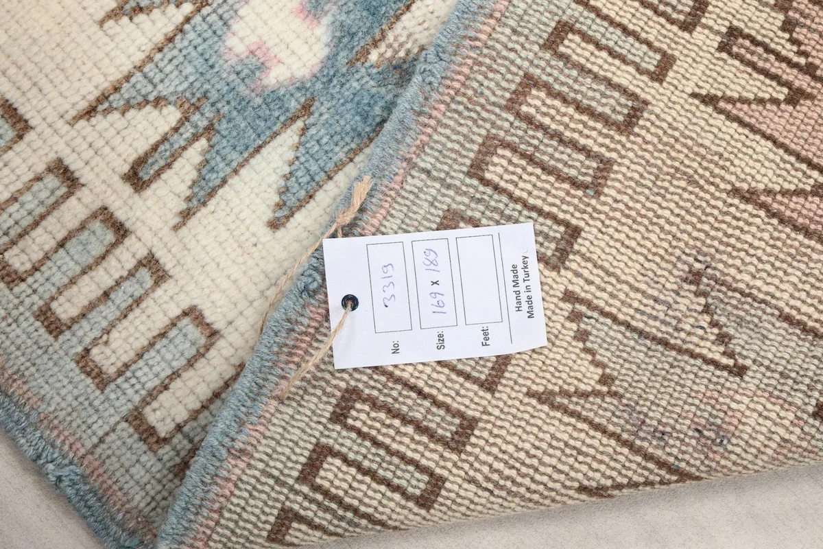 Close-up of the rug's back with a tag showing origin and size details