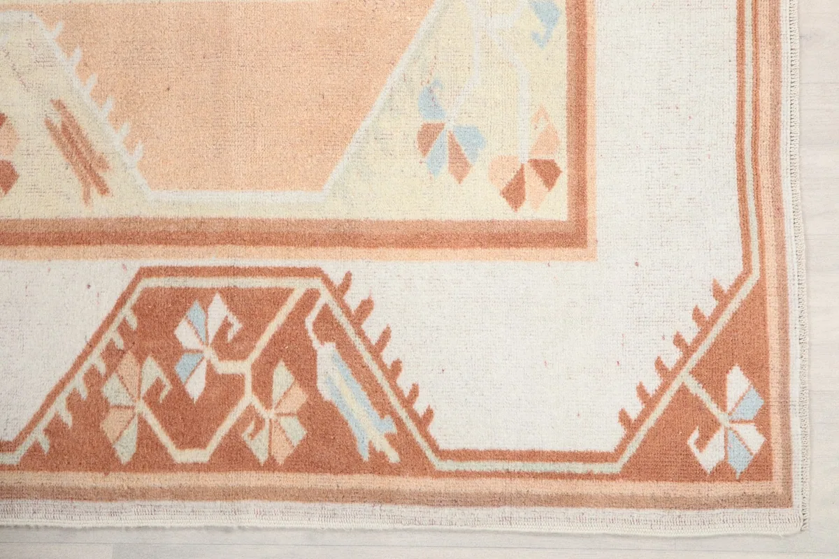 Detail of the orange border with tribal patterns and a corner of the cream field