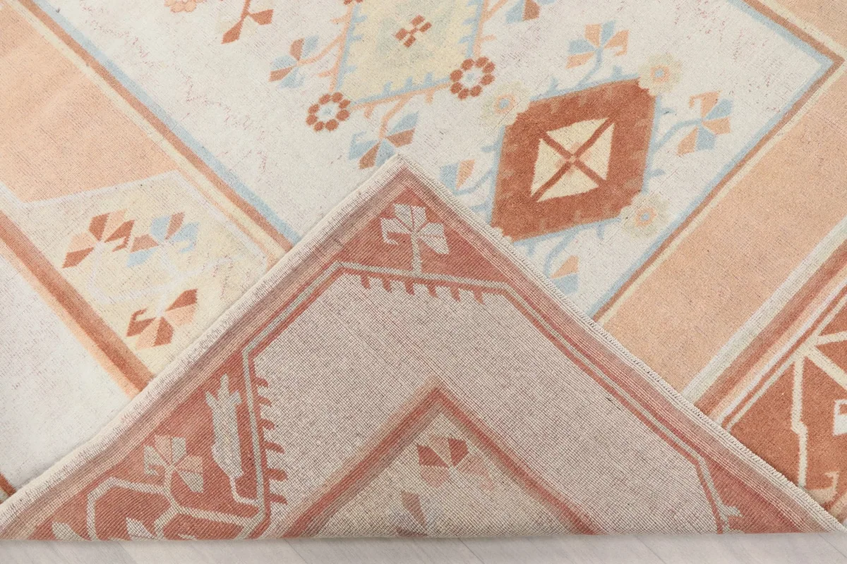 Corner of the rug folded back to reveal the wool pile and cotton foundation texture