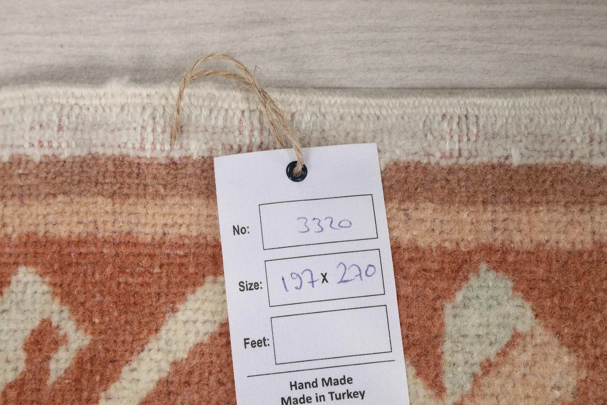 Close-up of the rug's tag with size information '197 x 270 cm' and 'Hand Made in Turkey'