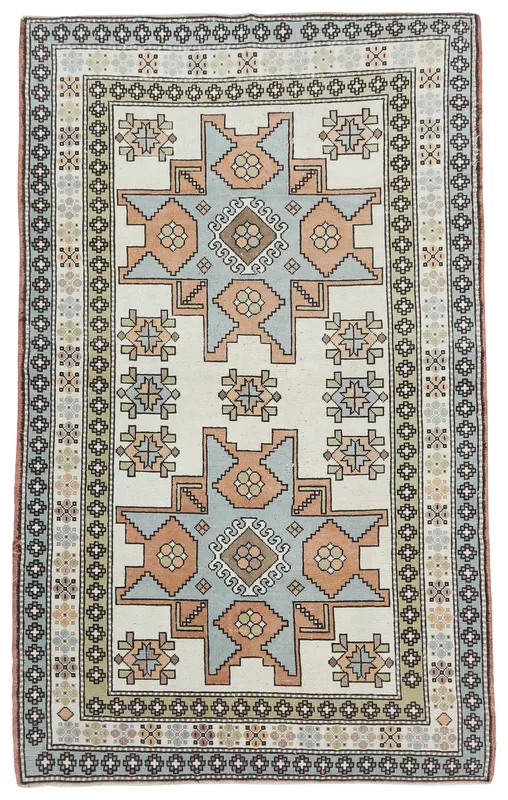 Full overhead view of the vintage Anatolian rug with ivory, orange, and blue geometric patterns