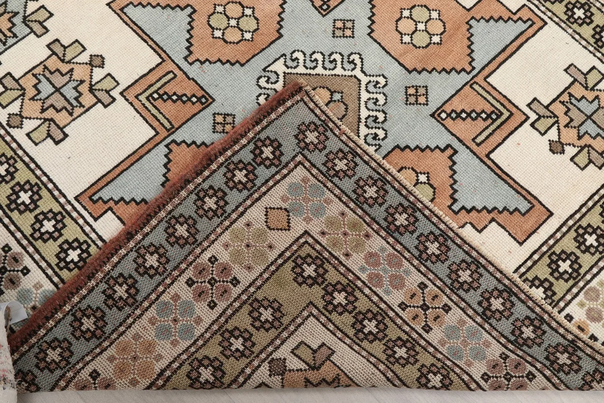 Folded corner of the rug revealing the hand-knotted cotton foundation and wool pile