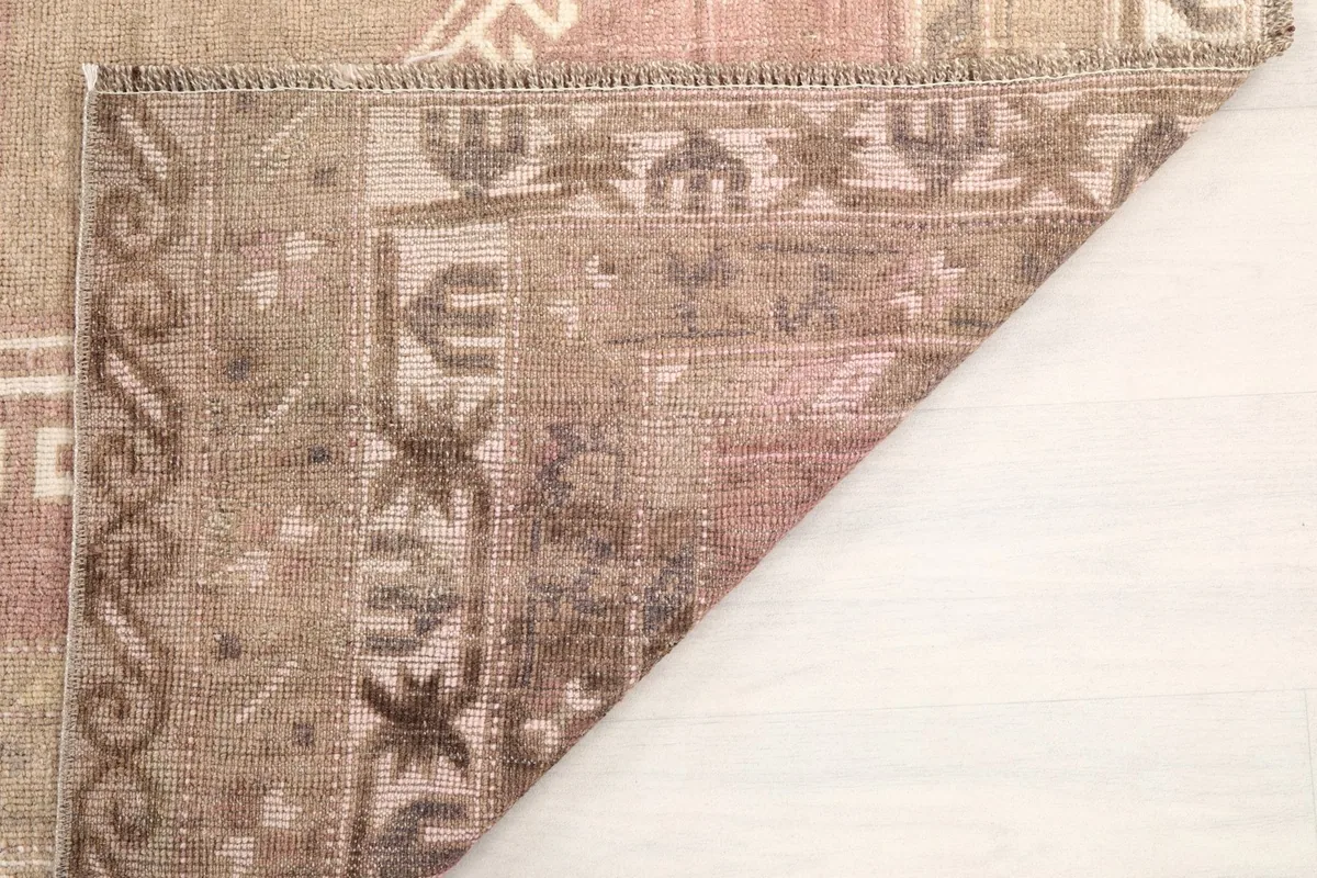 Corner folded back to reveal the hand-knotted cotton foundation and the reverse side of the rug