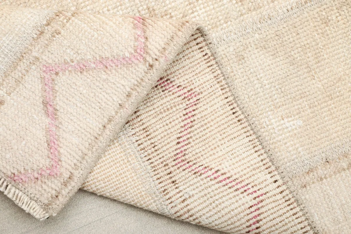 Folded section of the rug revealing the back of the weave and the fringe detail